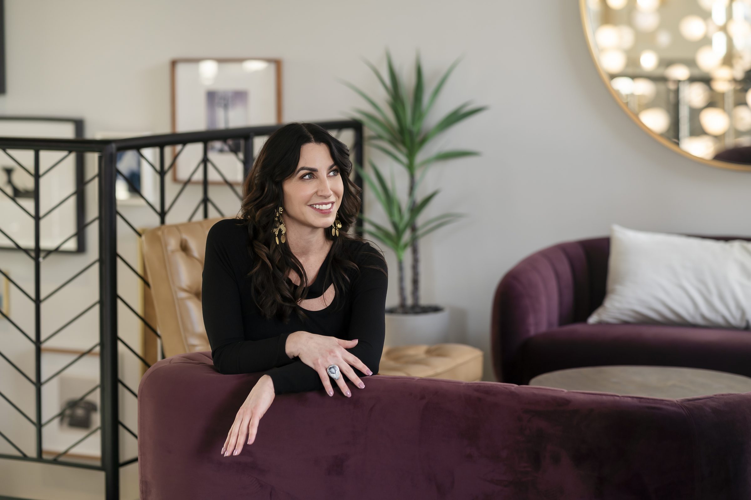 Susan Page seated on a plum sofa